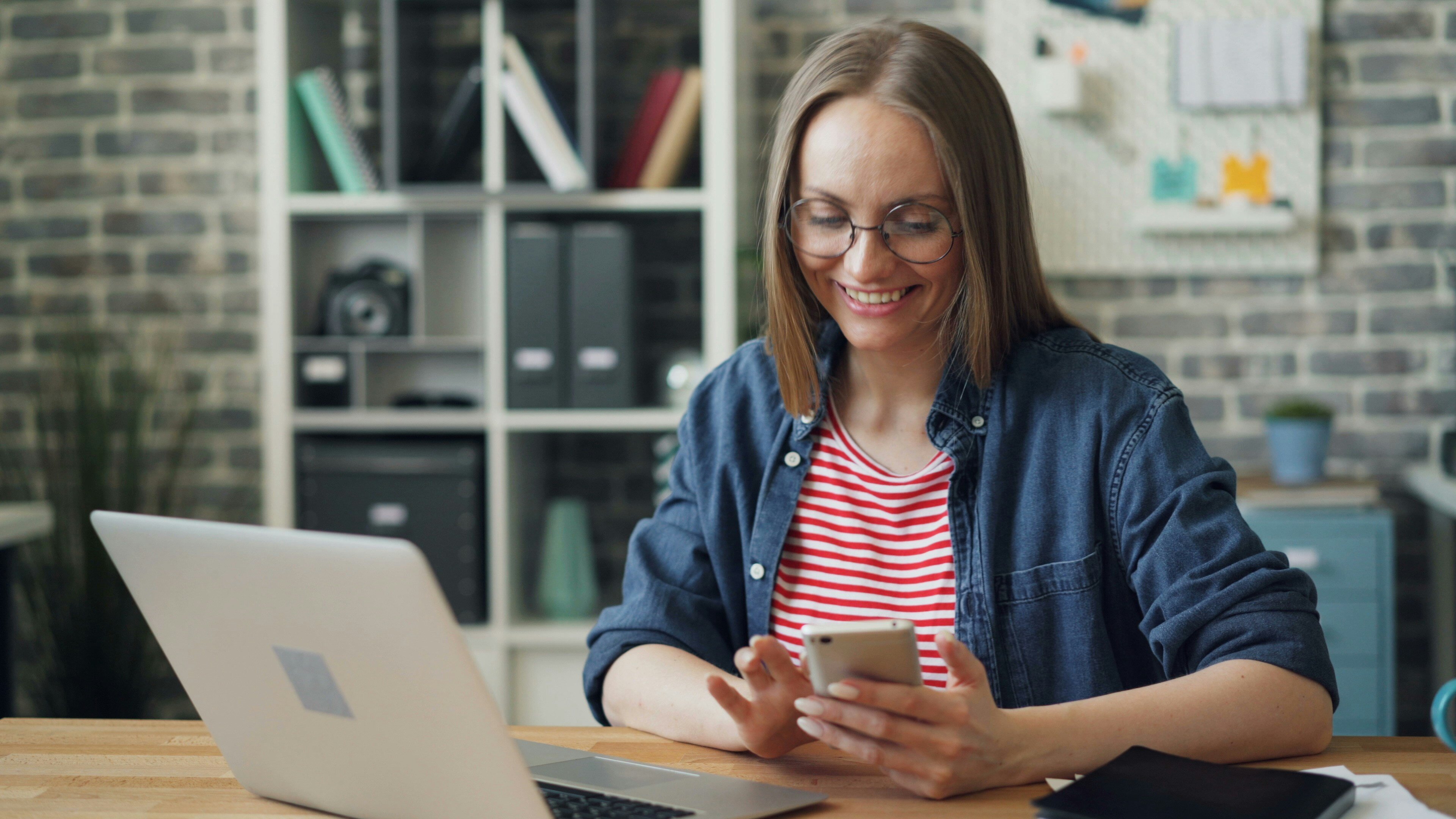 A woman smiling and looking at her phone